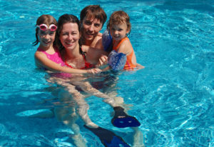 Happy family with kids in pool having fun, summer vacation